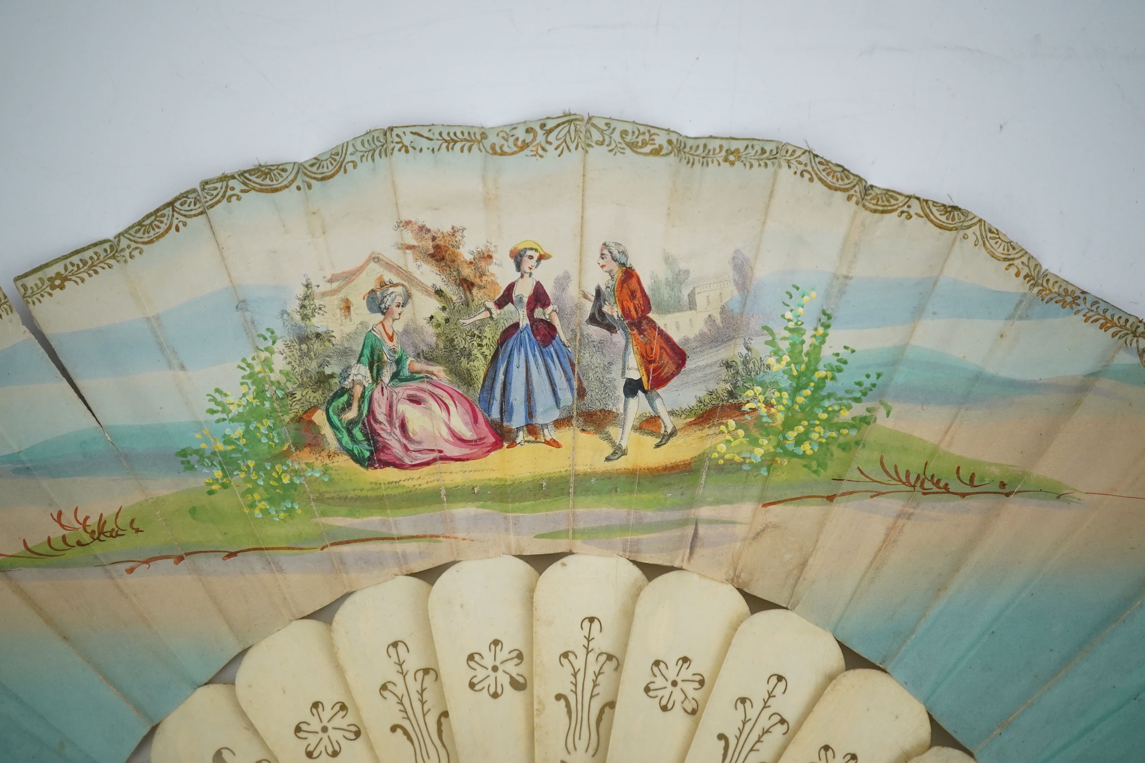 Three French fans: a mother of pearl and sequin fan boxed, a painted silk, feather and bone fan and a gilt decorated bone figural paper fan, the two bone fans having gilt mirrored mounts on the guards, figural paper fan